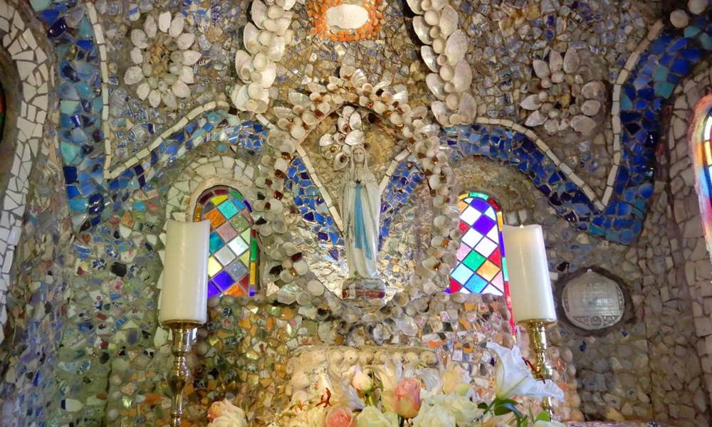 The main altar is beautifully decorated with pebbles, seashells and pieces of china