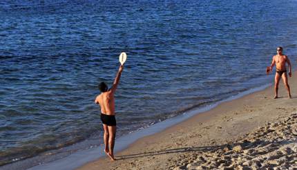 Two men playing matkot on the beach