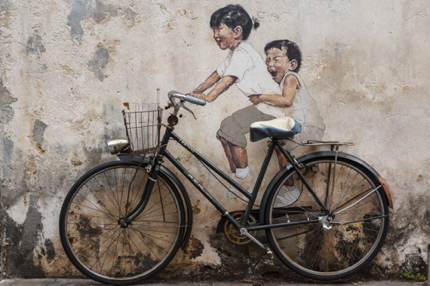 Wall art of a brother and sister riding a bike