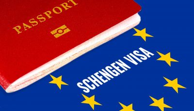 Red passport on Europe flag background with Schengen Visa in the circle of stars